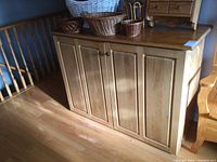 Front view of solid oak cabinet showing four paneled doors and wood finish.