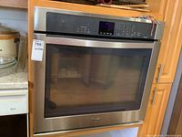 Front view of the stainless steel built-in Whirlpool oven insert showing control panel and large glass door.