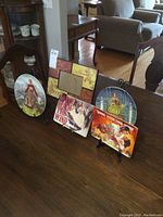 Overview of 4 Gone With the Wind plates on table with 5x7 frame and stands in background.