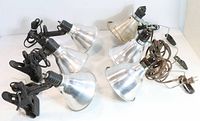 Six clip lamps arranged to show shades, clamps, and cords.