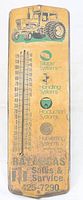 Front view of vintage metal thermometer with a yellow background, green tractor graphic, and temperature scale in Fahrenheit and Celsius. Includes advertising text and system icons below the graphic. Shows rusty patina.