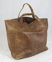 Front angled view of the vintage brown pebble leather tote bag with two short handles, showing texture and shape.