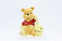 Front view of the ceramic Winnie The Pooh figurine with honey pot.