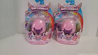 Two new Hatchimals toys in original packaging with pink eggs and purple heart designs.