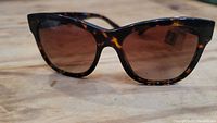 Front angled view of full sunglasses showing tortoiseshell frame and lens tint