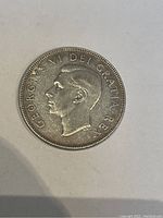 Obverse side of the 1951 Canadian 50 cent coin showing King George VI portrait and inscription.