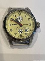 Front view of Timex automatic watch with cream dial, Arabic numerals, 24-hour subdial, power reserve subdial and red seconds hand.