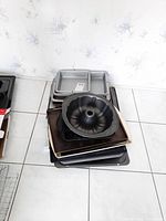 Stack of various baking pans including rectangular, bundt cake pan, and flat baking sheets.