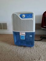 Front view of Simplicity dehumidifier showing water tank and Canada made label.