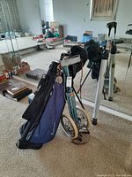 Image showing right hand golf clubs in a blue Nike bag with a golf push cart and covers for some clubs.