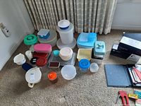 Wide view showing entire collection of various plastic kitchen storage containers in multiple colors and sizes.