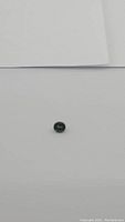 Oval cut tsavorite garnet gemstone on white background, showing color and shape