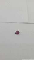 Loose pear cut ruby on white background at angle
