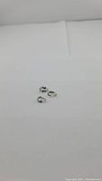 Three pear cut teal green Prasiolite gemstones displayed on white background