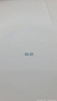 Two small light blue rectangular-cut aquamarine gemstones laid on white background, showing size and color match.