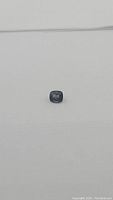 Front view of cushion-cut blue spinel on white background.