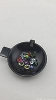 Loose gemstones displayed in black dish