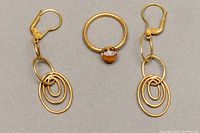 Photo showing full view of the earrings and the ring together on a gray background.