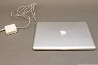 Top-down view of closed MacBook Pro next to MagSafe power adapter