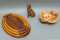Photo showing three vintage wooden oval nesting serving trays alongside the carved dog figurine and maple burl bowl.