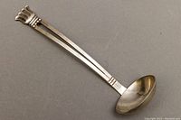 Top view of the entire sterling silver sauce ladle showing tulip handle and ladle bowl.