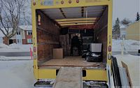 Interior view of yellow 16-foot moving truck loaded with household items.