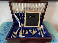 Overall view of wooden case containing silver-plated cutlery display
