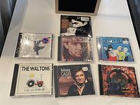 Lot overview showing 7 CDs from various artists including Prince, Johnny Cash, The Waltons, Die Ärzte