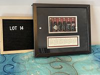 Framed shadow box with miniature Coke bottle figurines and descriptive text alongside lot number board