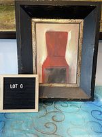 Frontal photo of the framed giclee art depicting a red chair, showing the entire frame and artwork.