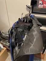 Blue and black golf stand bag holding clubs and travel case