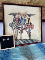 Framed reproduction artwork showing three women riding unicycles with a textured background, signed or identified as "Holiday on Wheels" by Graciela Boulanger, with visible red frame and condition details.