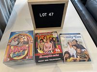 View of all three DVD sets together with a sign indicating lot number 47. The three sets are The Partridge Family, Family Ties, and Happy Days seasons 1-6.