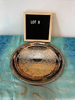 Top-down photo of the vintage silverplate serving tray showing the engraved floral and scroll pattern with tarnish particularly visible on one side