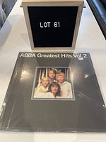 Photo of the ABBA Greatest Hits Vol. 2 vinyl record cover showing the band members and visible scratches on the cover.