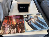 Photo of two The Spinners vinyl LP records side by side with Lot 59 sign behind.