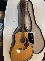 Full-sized Yamaha Eterna EF-31 acoustic folk guitar resting inside a hard case with lid open.