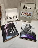 Four Beatles and John Lennon books laid out, showing front covers and jackets.