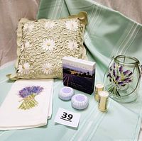 The full lot including soaps, towel, pillow, candle lantern, and talcum powders arranged on cloth background