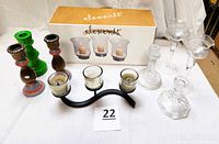 Full view of candlesticks and candle holders including boxed Elements hurricane candle holders, various glass, wooden, ceramic, and metal candle holders.