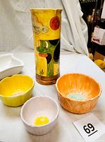 Photo showing colorful tall pitcher with cow and sky design and three nesting bowls in yellow, orange, and pink with matching colored interiors