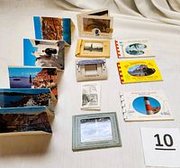 Image showing all nine mini postcard sets and boxes laid out on a table, displaying their various sizes and original holders