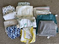 Top view of 12 assorted receiving baby blankets stacked together showing various patterns and colors.