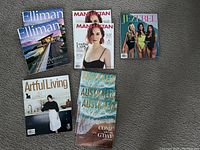 9 assorted magazines including Elliman, Manhattan, Jezebel, Artful Living, and Australia travel magazines, visible covers.