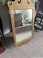 Full view of the antique mirror showing frame design and reflection.