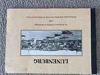 Front cover of the Lunenburg book with an upside-down photograph of historic buildings on beige background.
