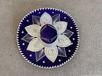 Top view of the purple Mexican sombrero showing detailed white and silver embroidery in floral designs and decorative patterns