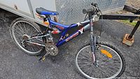 Full side view of blue and black Voodoo mountain bike showing frame, tires, handlebar, and seat.