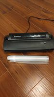 FoodSaver V2244 vacuum sealer unit and vacuum sealer bags on wooden floor.