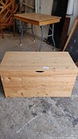 Full frontal view of the homemade pine wooden box with the lid closed, showing finger hole detail and natural wood texture.